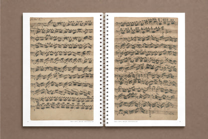 Senza Basso — open notebook with the first pages of Suite 1 in Anna Magdalena Bach's hand, at 78% of actual size, digitally composed product view