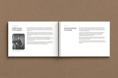 Brahms — Handel Variations, Op. 24 — open notebook at the pages on Clara Schumann and the premiere, with her 1857 portrait, digitally composed product view